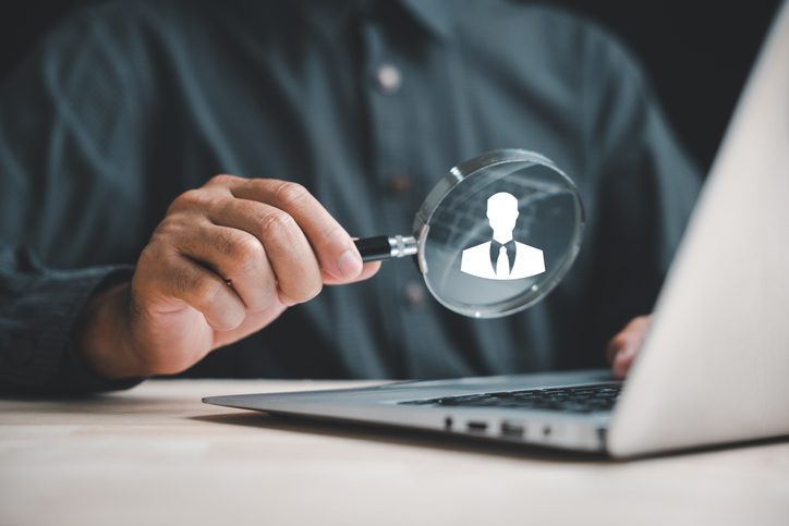 Exploring HRM Magnifier glass zooms in on manager icon among staff icons, symbolizing importance of human resource management in recruitment, leadership, and customer targeting. employees selection